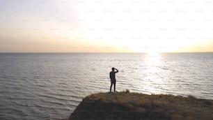 L’homme debout sur la côte rocheuse de la mer