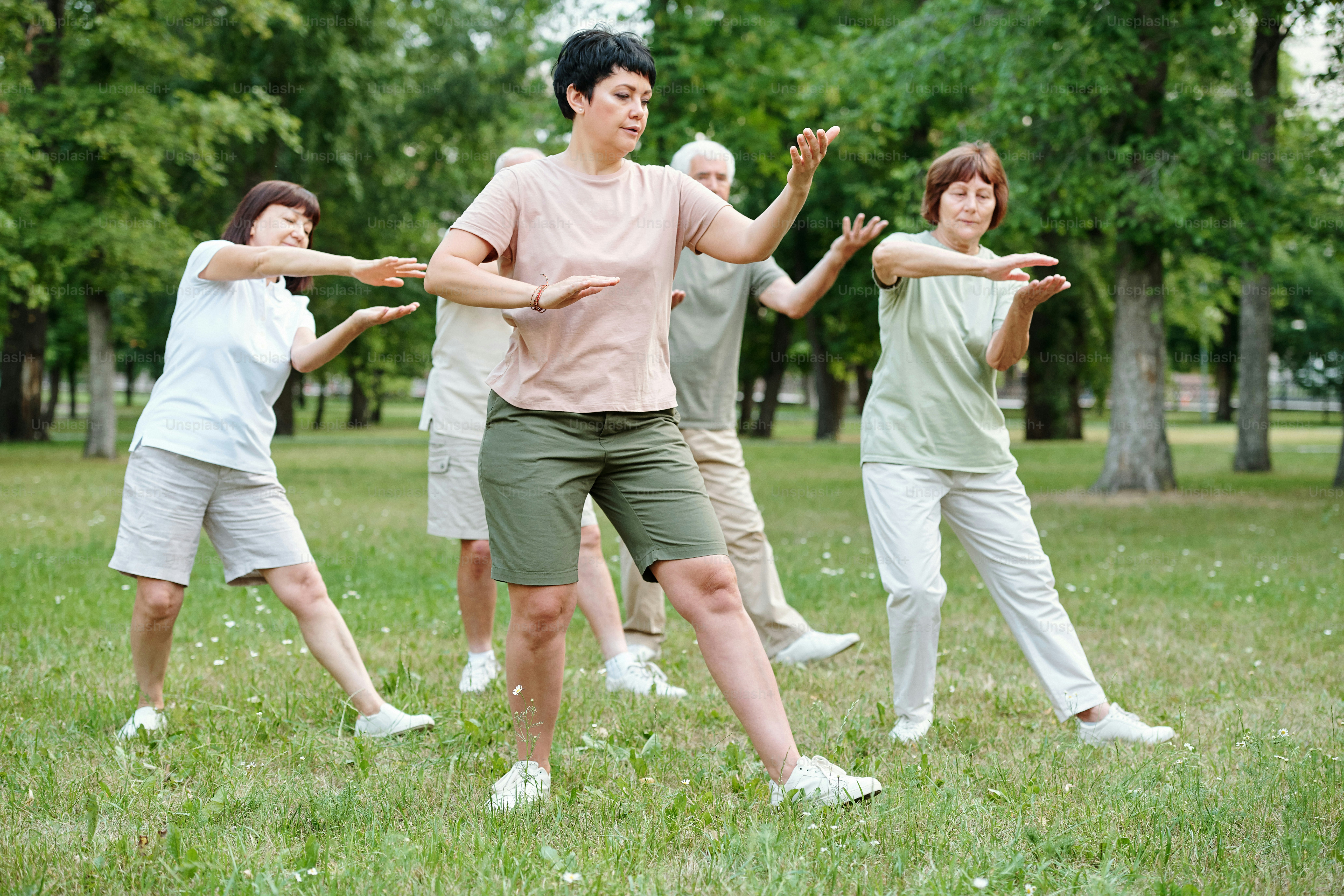 Gruppo di persone mature che si esercitano durante l'allenamento sportivo nel parco all'aperto