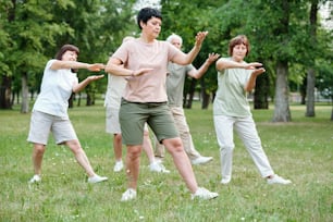 Grupo de pessoas maduras que se exercitam durante o treinamento esportivo no parque ao ar livre