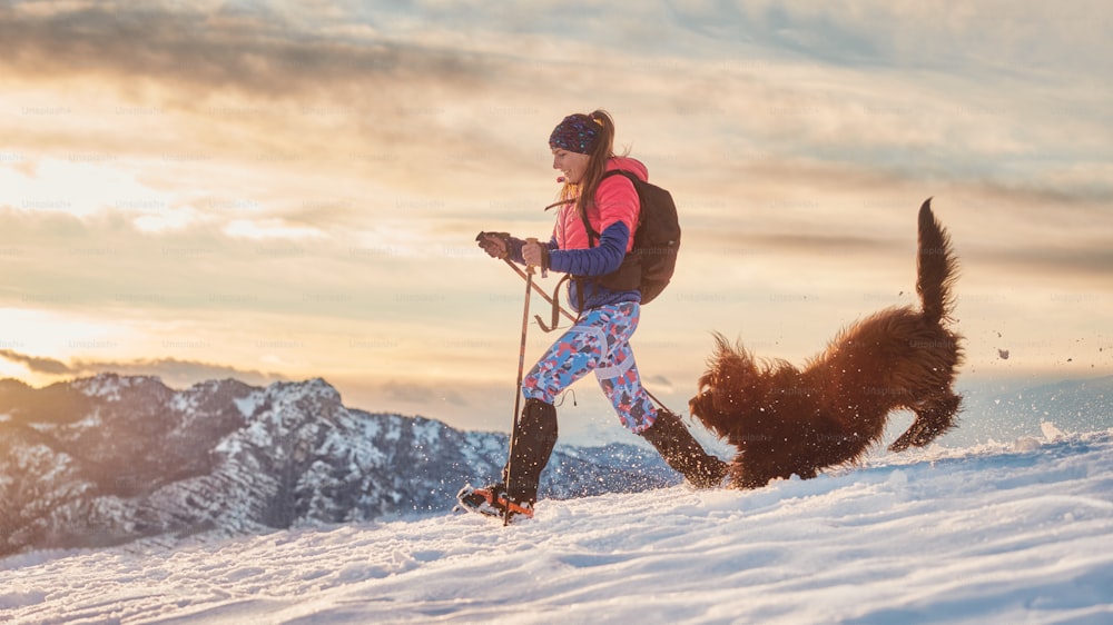 Lovebirds girl and her dog play in the snow during a winter hike