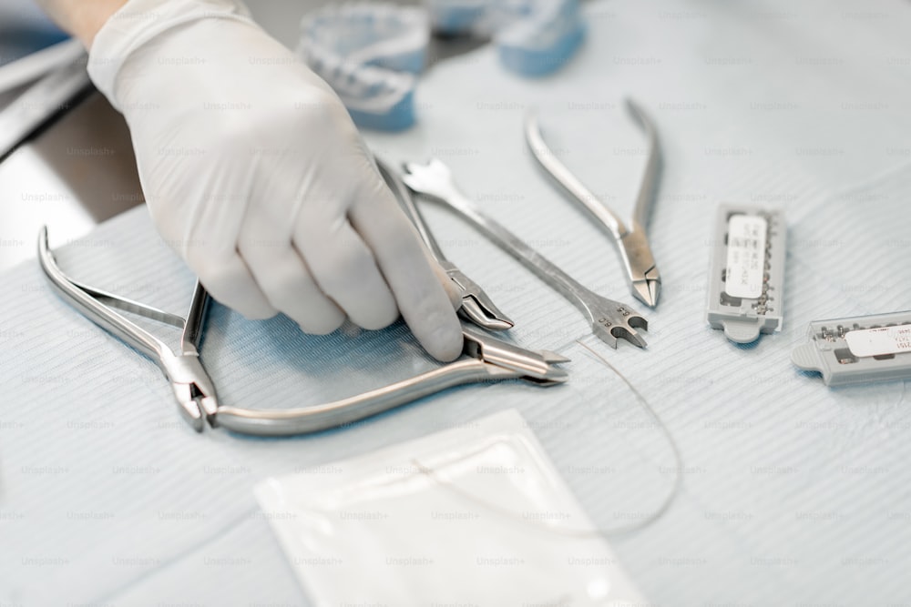 Kieferorthopäde arbeitet mit einem Zahnmodell und nimmt Instrumente vom Tisch. Kieferorthopädische Behandlung im Labor. Nahaufnahme. Hochwertiges Foto