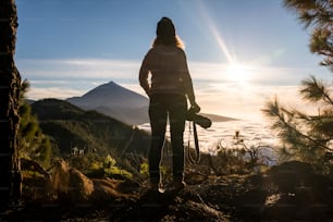 활동적인 라이프스타일을 탐험하는 야외 공원 계곡 레저에 서 있는 여자 - 여행의 자유와 산에서 대체 관광 휴가 - 배경에서 놀라운 일몰 전망을 가진 여성