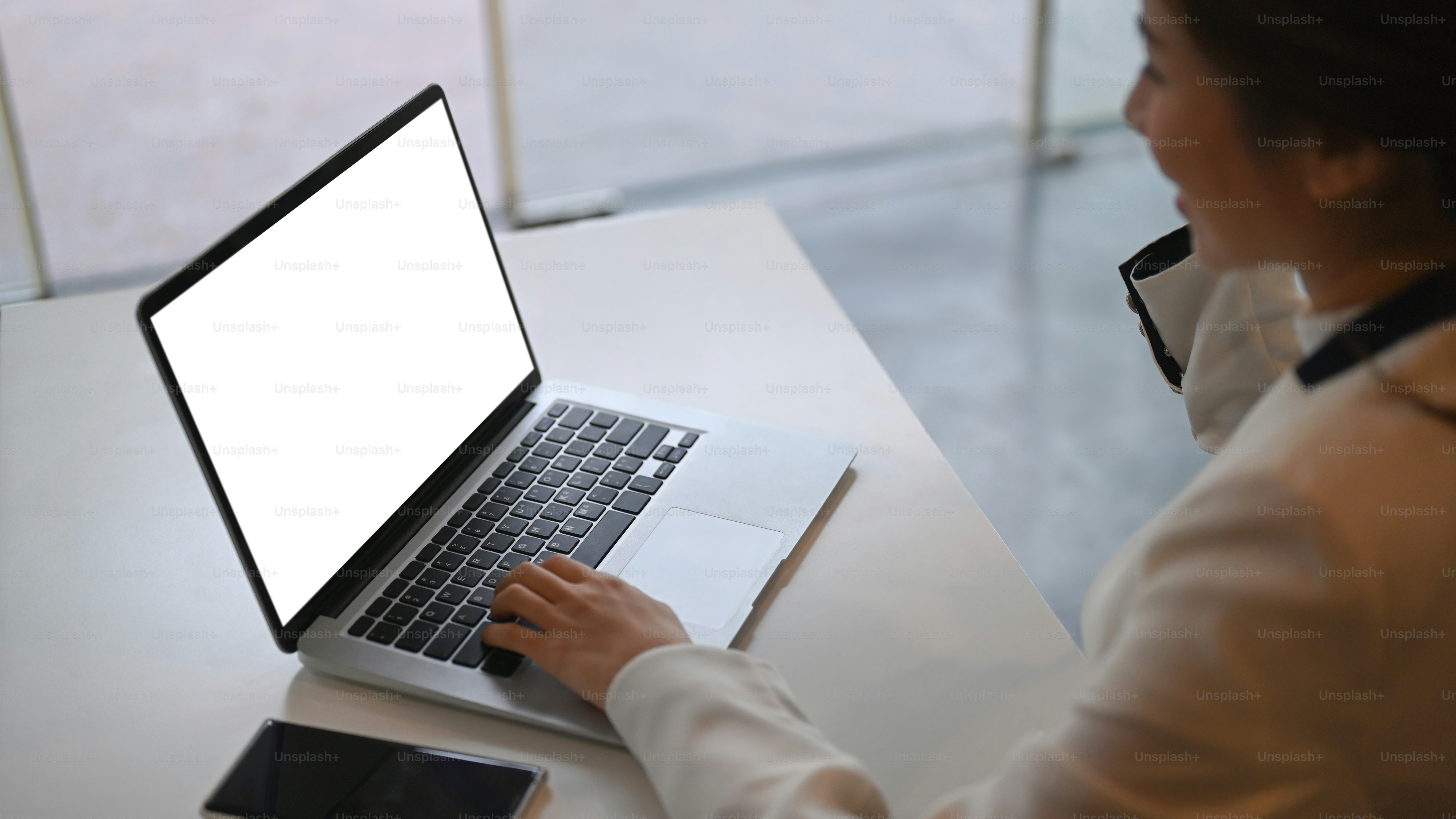 Cropped shot of smiling businesswoman searching information on laptop computer at office desk.