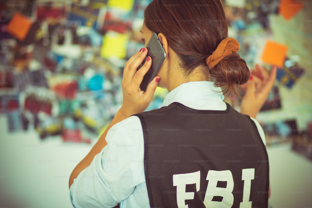 Mulher do FBI no cargo falando ao telefone.