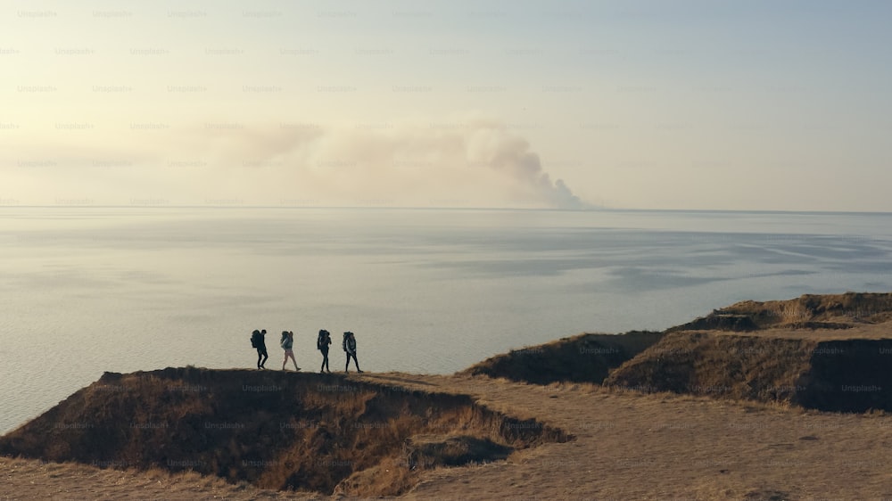 The four tourists walking on the rocky coastline