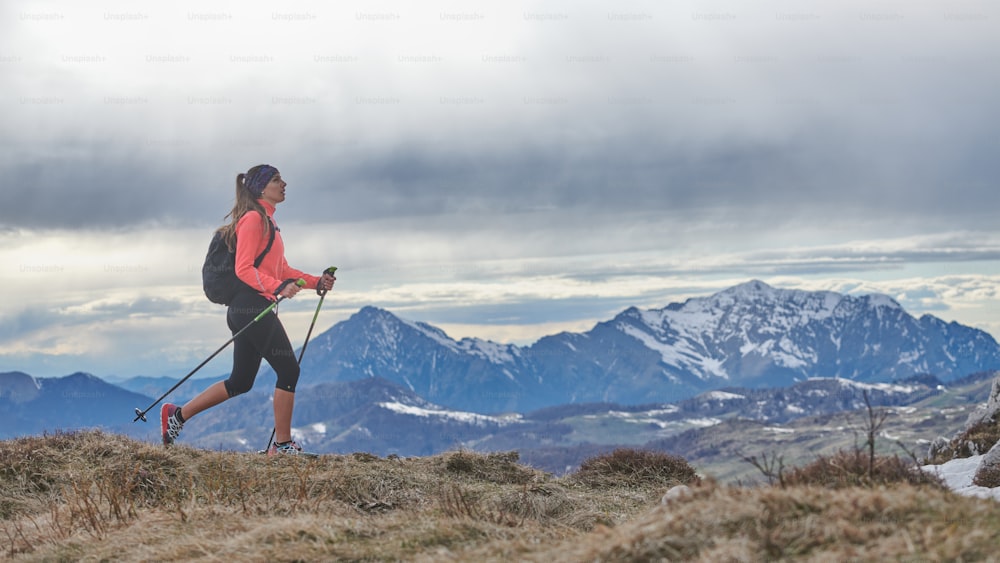 Uma menina andando nórdica andando sozinha nas montanhas