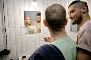 Heureux jeune homme gay regardant son petit ami dans la salle de bain