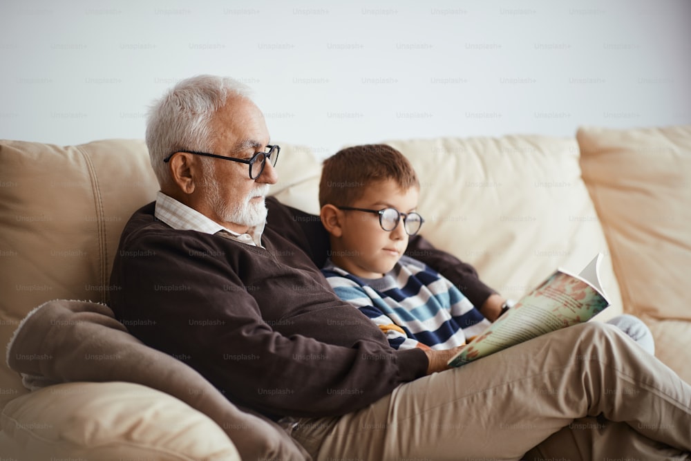 Homem idoso contando histórias para seu neto enquanto passavam o fim de semana juntos em casa.