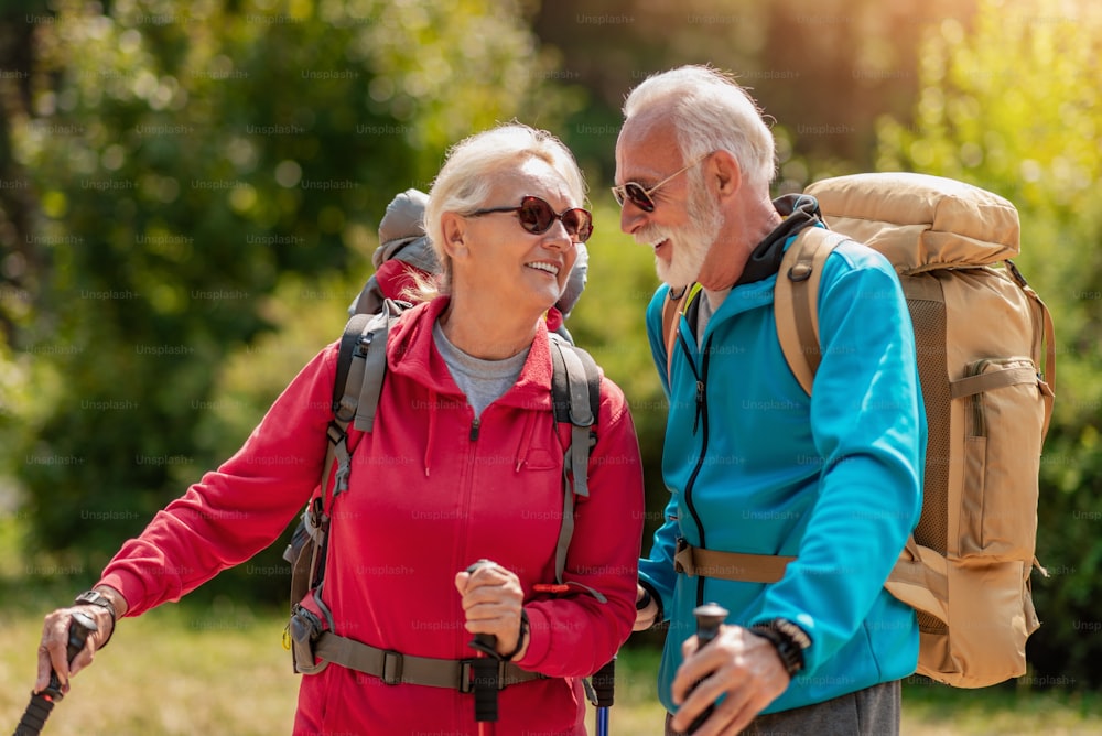 Senior couple with backpacks on hiking have fun in nature. Love, people, nature and lifestyle concept.