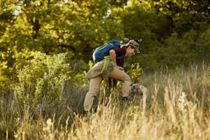 Young happy woman hiking in nature with her dog.