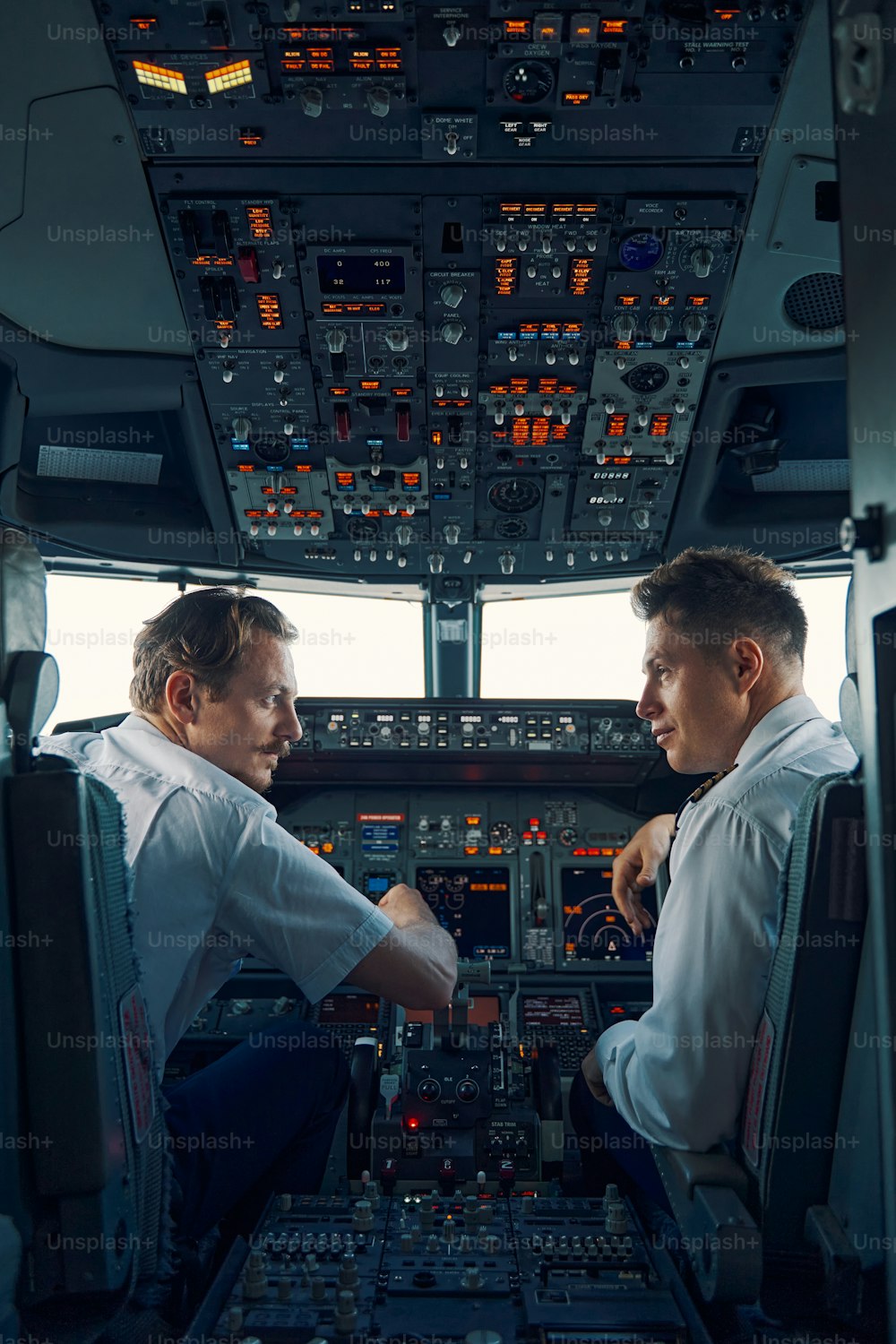 Back view of a serious aircraft captain and a co-pilot seated in the flight deck