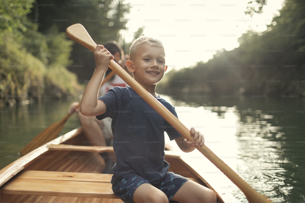 아름다운 화창한 날에 아버지와 함께 카누를 노를 젓는 법을 배우는 소년.