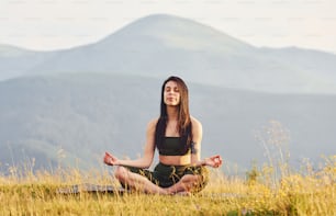 Beautiful young woman doing yoga exercises. Majestic Carpathian Mountains. Beautiful landscape of untouched nature.