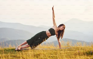 Belle jeune femme faisant des exercices de yoga. majestueuses montagnes des Carpates. Beau paysage de nature intacte.