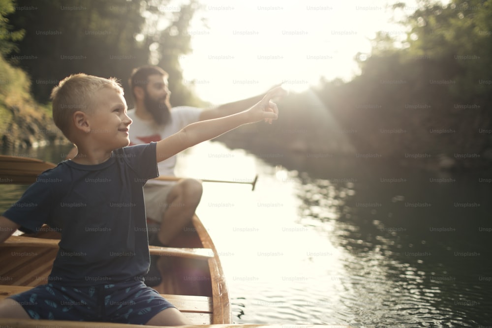 Menino aprendendo a remar canoa com seu pai em um belo dia ensolarado.