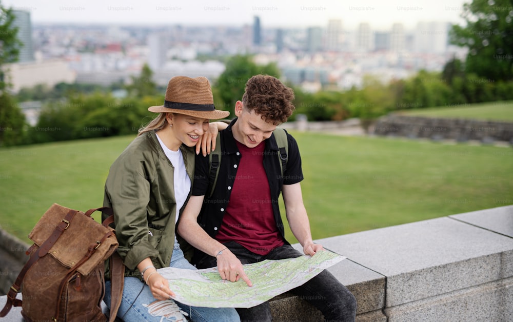 Portrait of young couple travelers with map in city on holiday, resting and planning.