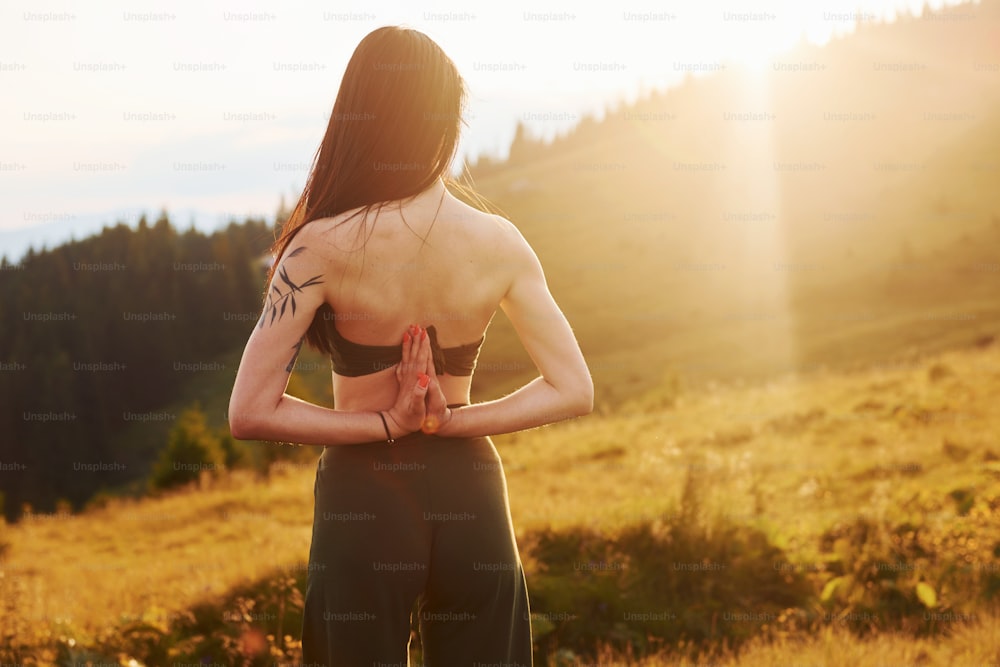 Sportive woman loves doing yoga. Majestic Carpathian Mountains. Beautiful landscape of untouched nature.