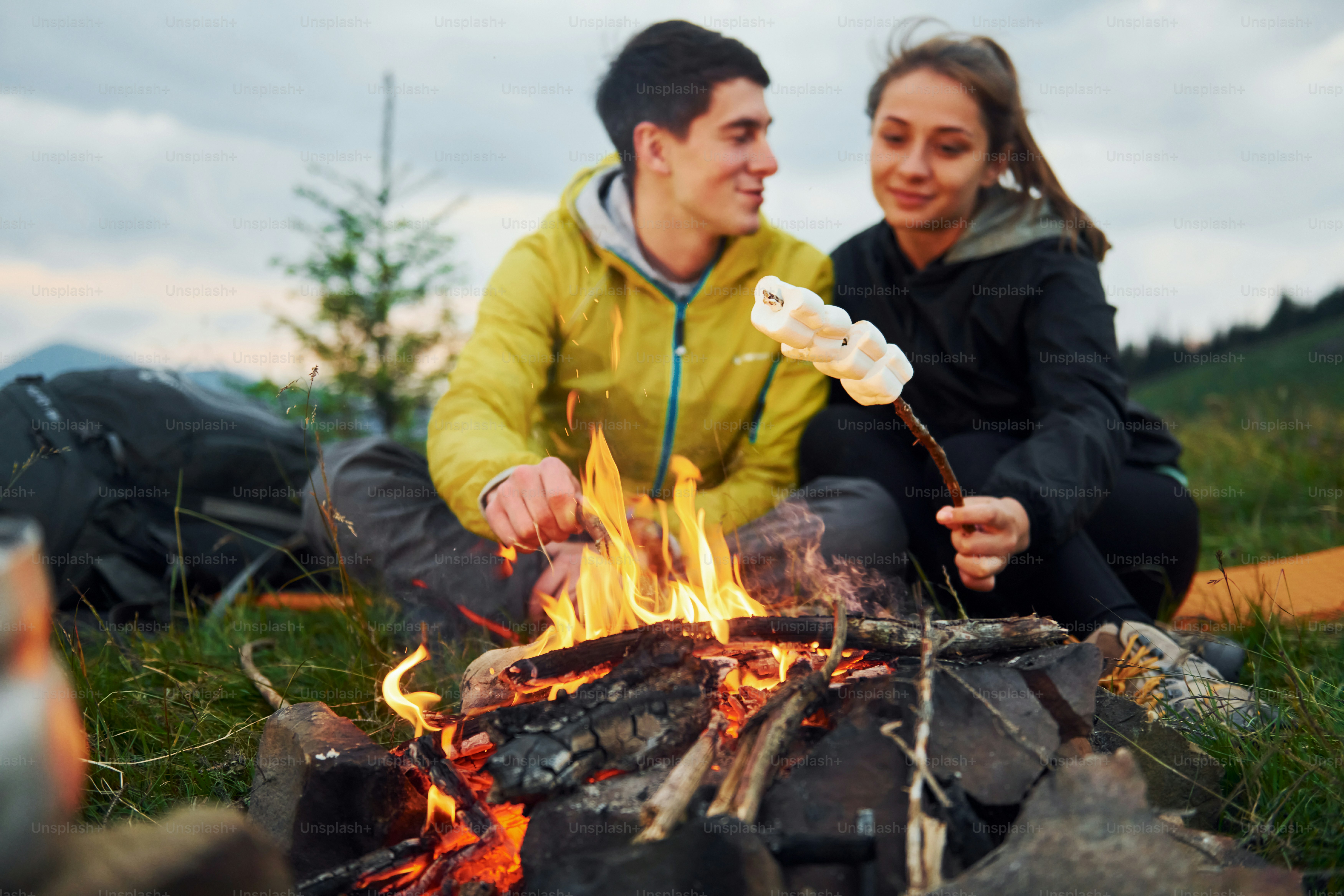Klassische Marshmallow-Herstellung am Lagerfeuer. Junges Paar. Majestätische Karpaten. Schöne Landschaft von unberührter Natur.