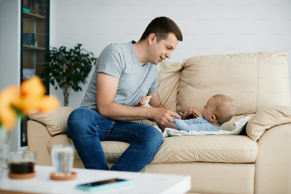 집에서 아기와 함께 시간을 즐기는 젊은 돌보는 아버지.