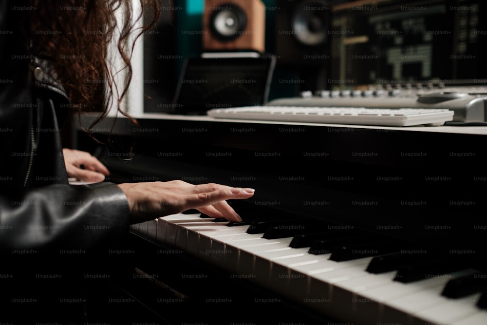 Close up of female hands playing keyboard at home recording studio, side view