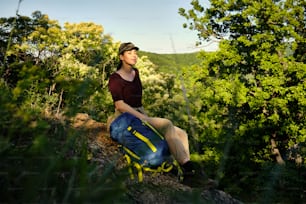 Carefree woman taking a break and relaxing with eyes closed while hiking in nature.