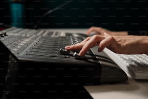 Close up of female hands using stage mixer controller in professional recording studio, moving controller bars