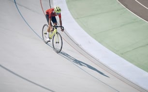 Top view of man in sports clothing cycling on track outdoors