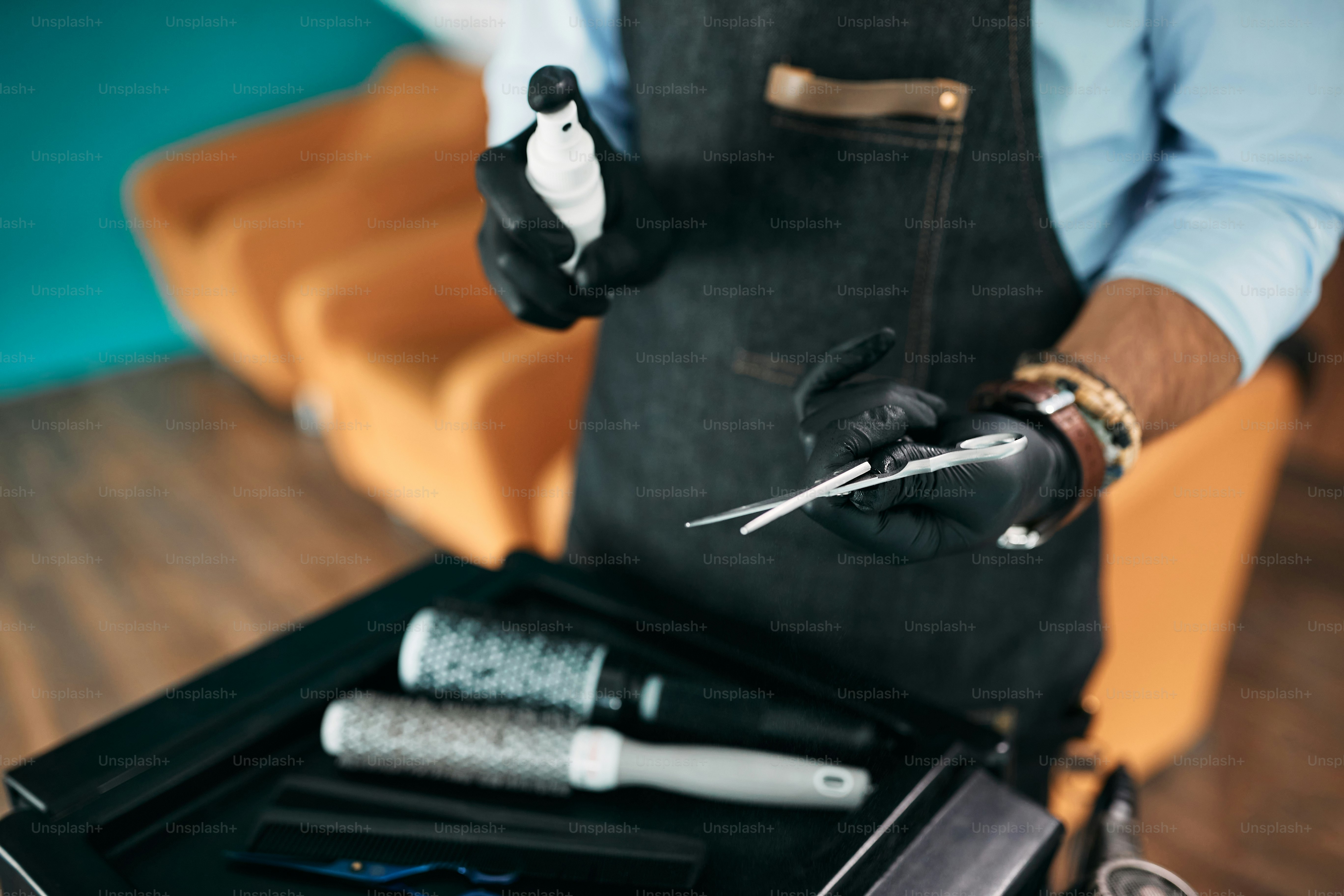 Close-up of hairdresser cleaning hair cutting scissor with disinfectant ...