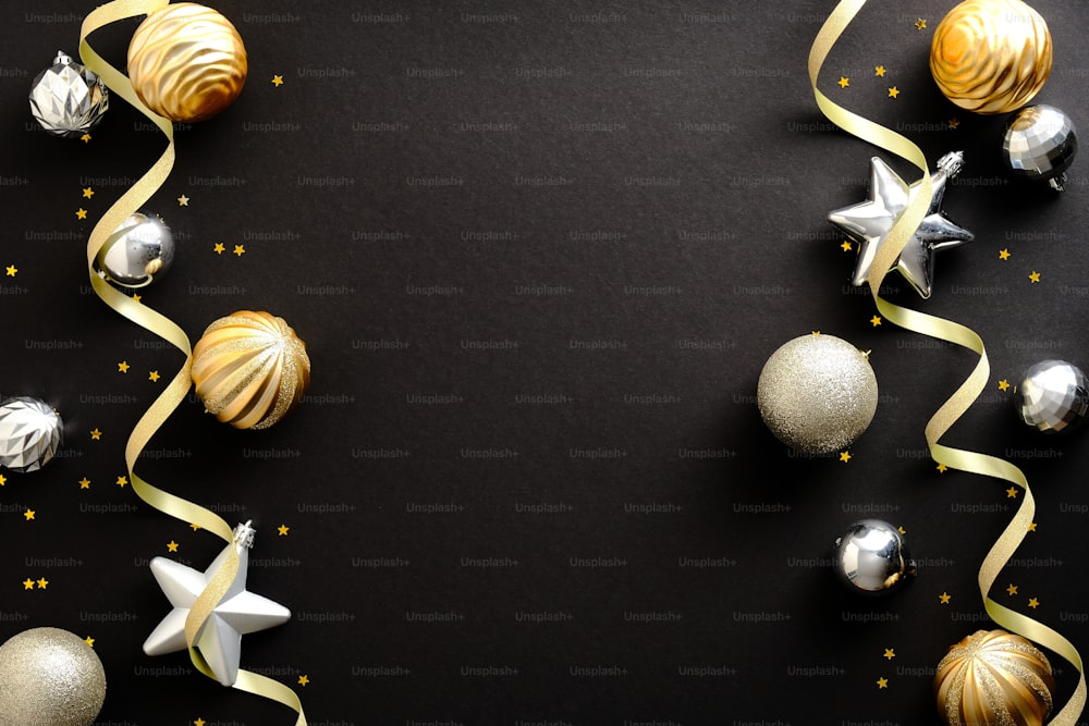 Merry Christmas and Happy New Year greeting card design. Christmas golden and silver ornaments on black background. Top view. Festive Christmas frame, banner mockup.