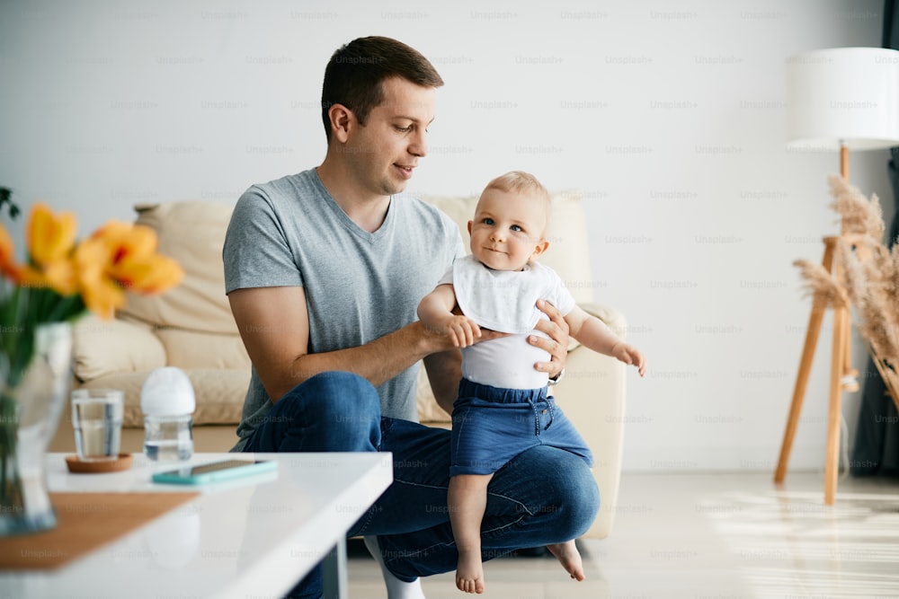 Young father and his baby son enjoying together at home. Copy space.