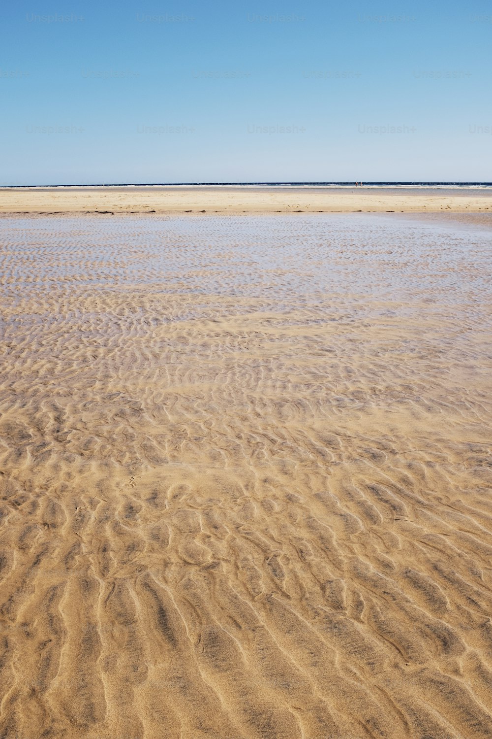 Sand- und Strandlandschaft mit transparentem, sauberem tropischem Meerwasser. Blauer Himmel im Hintergrund. Konzept des Sommerreiseurlaubs inmalerischer Ort