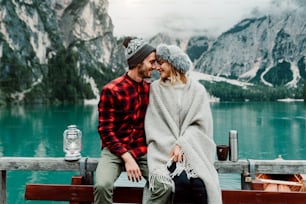 イタリアのブレイズの高山湖を訪れる大人のロマンチックなカップル。山を背景に愛する瞬間を過ごす恋の観光客。カップル、放浪癖、旅行のコンセプト。