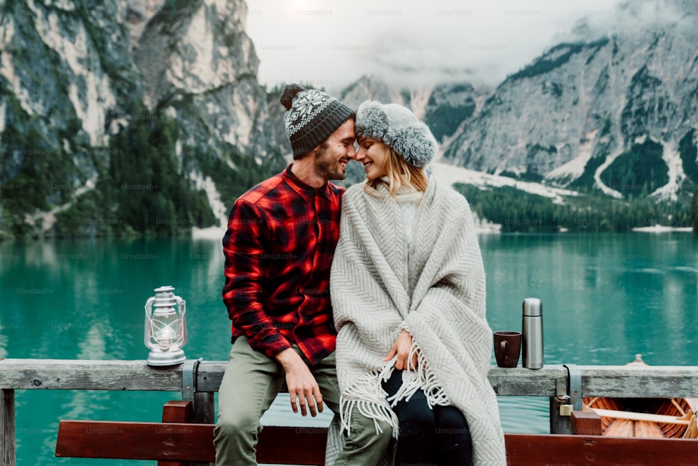 Romantic couple of adults visiting an alpine lake at Braies Italy. Tourist in love spending loving moments on a mountains background. Couple, wanderlust and travel concept.