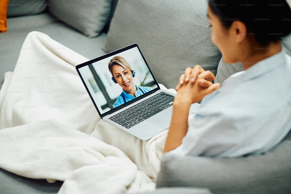 Smiling female doctor having video call with patient who is calling her from home via laptop.
