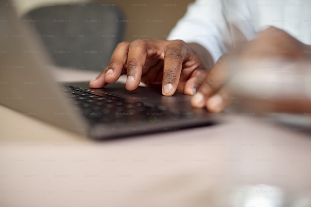 Gros plan d’un homme d’affaires afro-américain travaillant sur un ordinateur portable à son bureau.