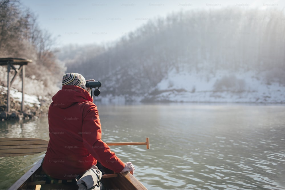 Rear view of man watching birds from the canoe.