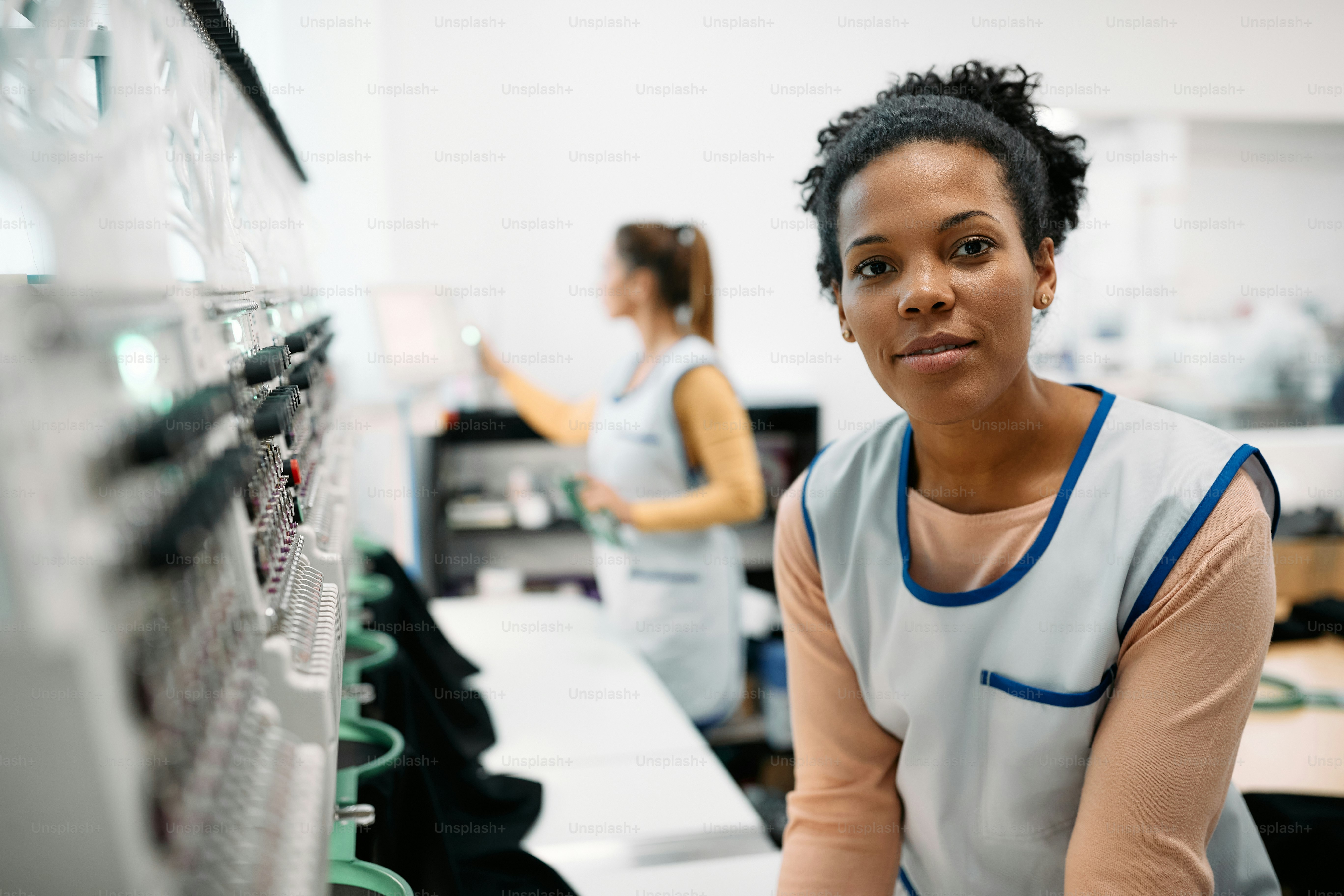Jeune couturière afro-américaine travaillant à la machine à broder dans ...