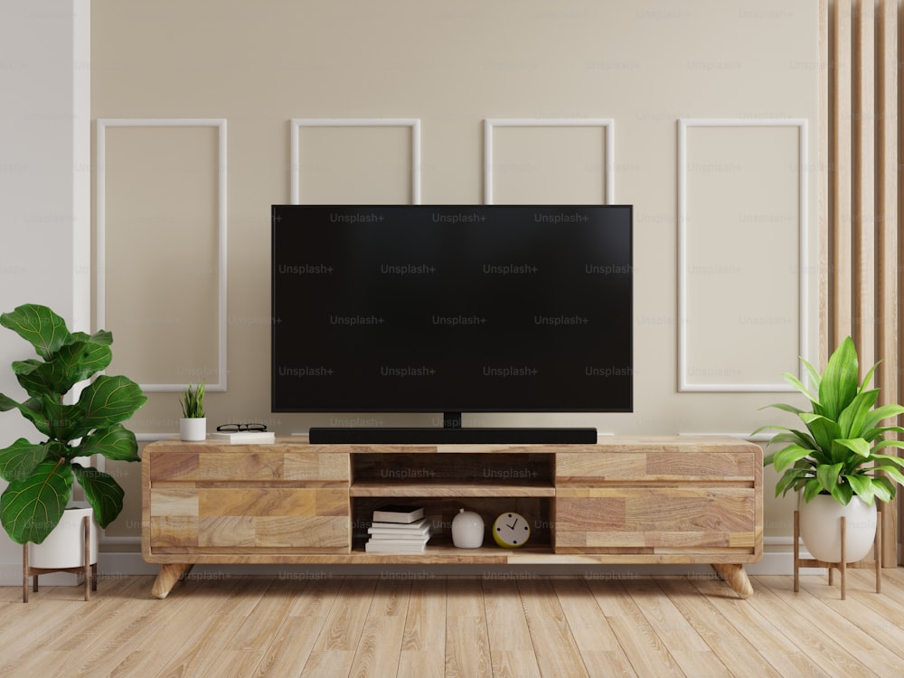 TV en gabinete con pared color crema y piso de madera.3d renderizado