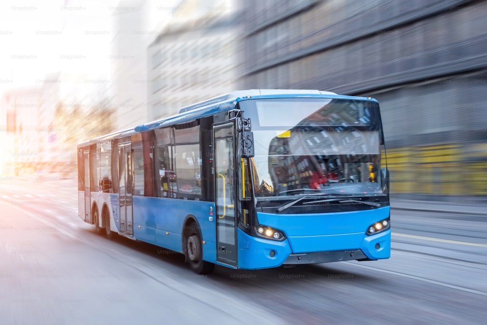 早朝に市内の道路を走行する青いバス