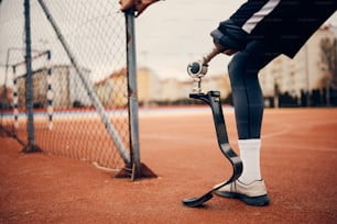 Close-up of athletic man with a prosthetic leg during sports training at the stadium.
