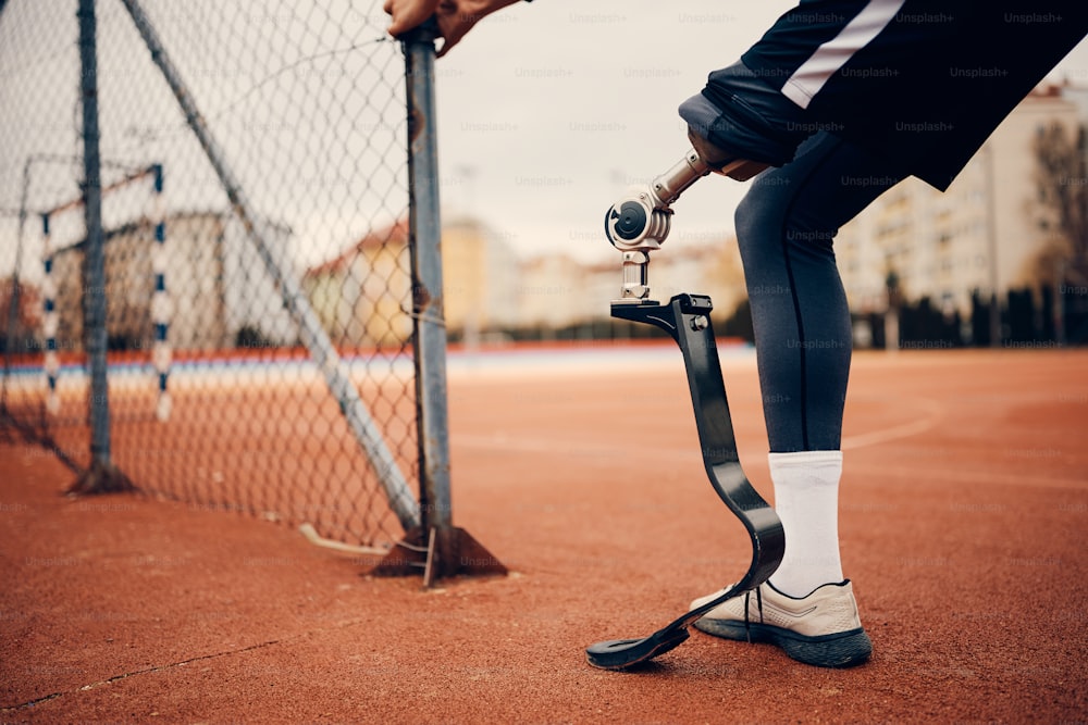 Close-up of athletic man with a prosthetic leg during sports training at the stadium.