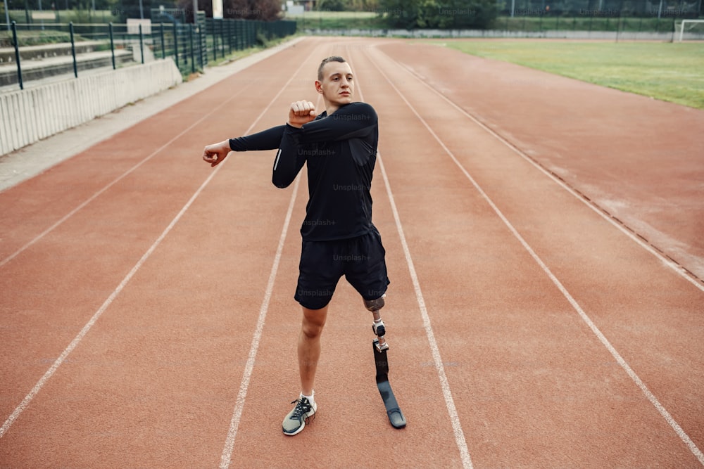 A sportsman with artificial leg warming up at stadium.