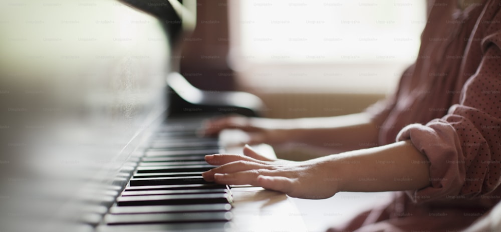 Ein junges Mädchen spielt Klavier mit ihren Händen