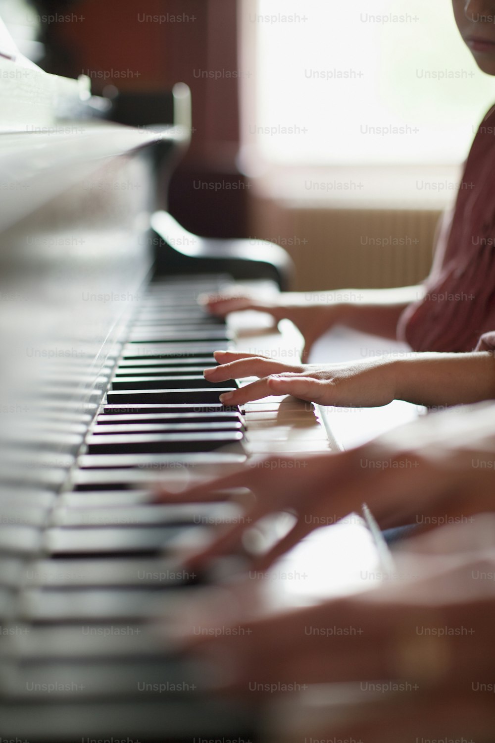 a young girl playing a piano in a room