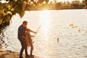 With catch. Father and son on fishing together outdoors at summertime.