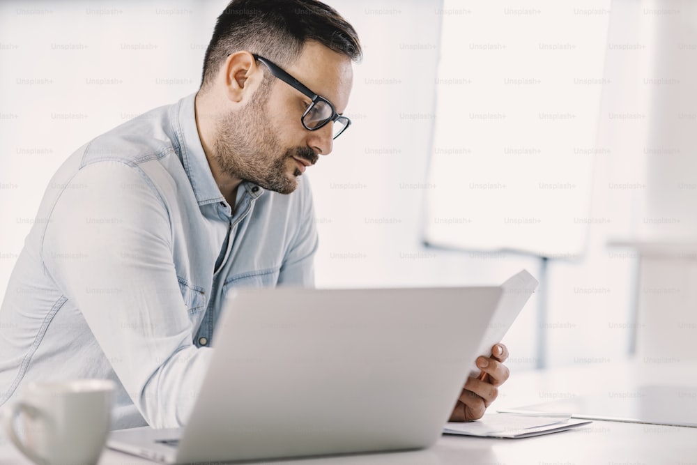 A remote employee sitting at home office and checking on paperwork.