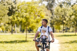 A father and little boy riding a bike in nature and practice healthy life.