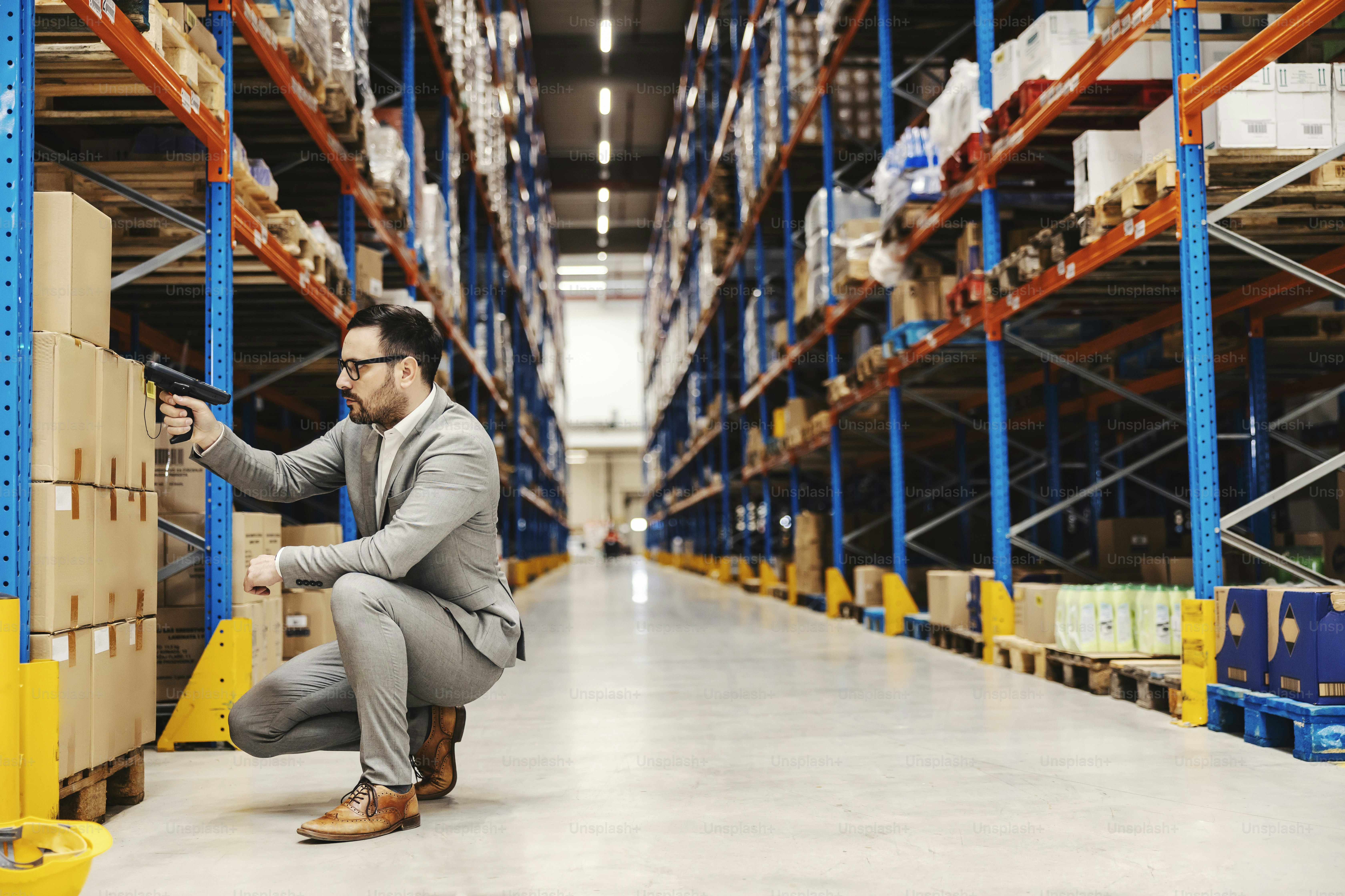 An inspector using qr and bar code scanner to check on order at storage.