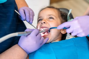 Foto de archivo de una niña linda durante la revisión en el dentista.