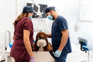 Foto de archivo de dos trabajadores de la clínica dental con la paciente durante su revisión.
